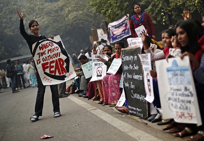 Protesters carry placards as they shout slogans during a protest to mark the first anniversary of the Delhi gang rape