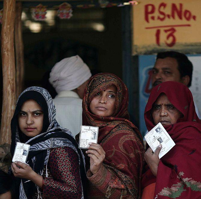 Voters queue inside a polling station to cast their vote during the Delhi assembly election.