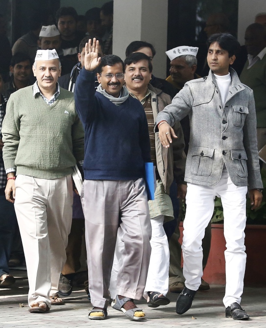 Arvind Kejriwal (centre), leader of the newly formed Aam Aadmi Party, waves after his meeting with the Delhi's Lieutenant Governor Najeeb Jung in New Delhi