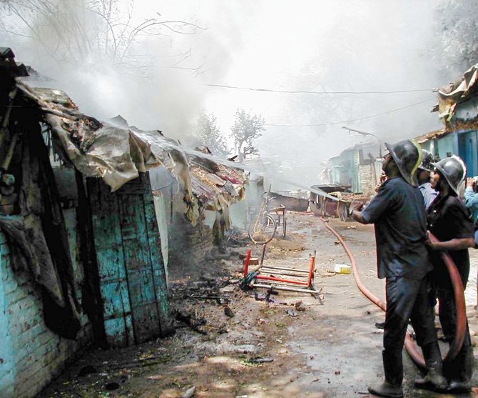 Firemen fights a blaze in a riot-hit neighbourhood of Ahmedabad in 2002