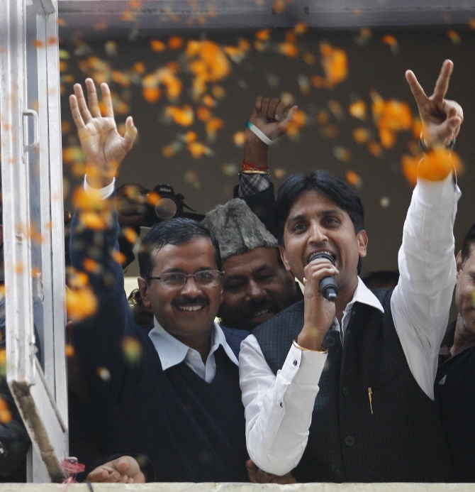 Delhi CM Arvind Kejriwal waves to the crwods as AAP leader Kumar Vishwas shows the victory sign in New Delhi