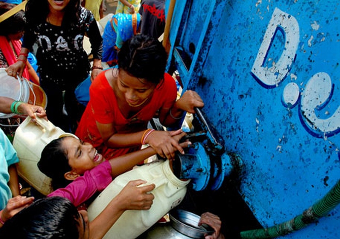 Residents of Govindpuri slum fight over water from a Delhi Jal Board tanker that empties in minutes. The slum colony has no regular water supply or sanitation facilities. Photograph: Sayantan Bera