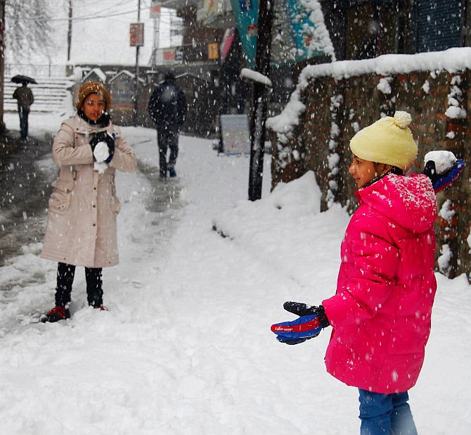 Tourists play in snow in Srinagar on Tuesday
