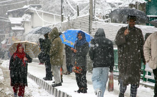 People walk during heavy snowfall in Srinagar on Tuesday