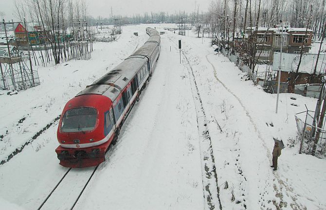 A train moves on snow-covered tracks during heavy snowfall in Kashmir on Tuesday
