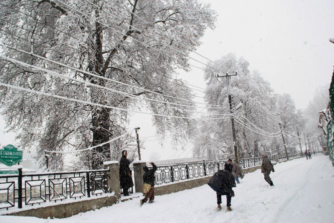Children play in the snow during heavy snowfall in Srinagar on Tuesday