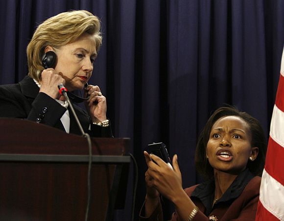 Hillary Clinton is assisted by a technician in adjusting her translation device during a news conference at the US embassy in Kenya's capital Nairobi
