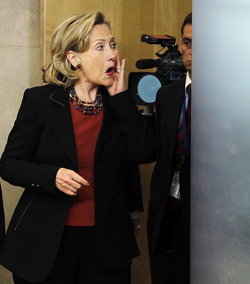Hillary Clinton adjusts her make-up before a news conference at the EU Commission headquarters in Brussels