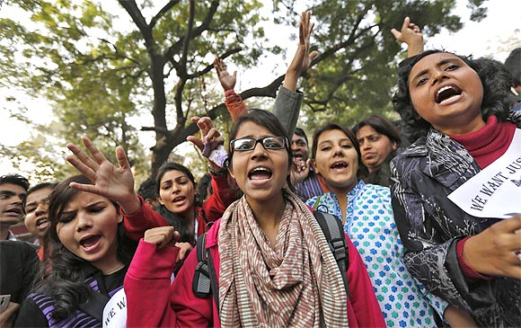 Demonstrators shout slogans and raise their hands during a protest against the Delhi gang rape