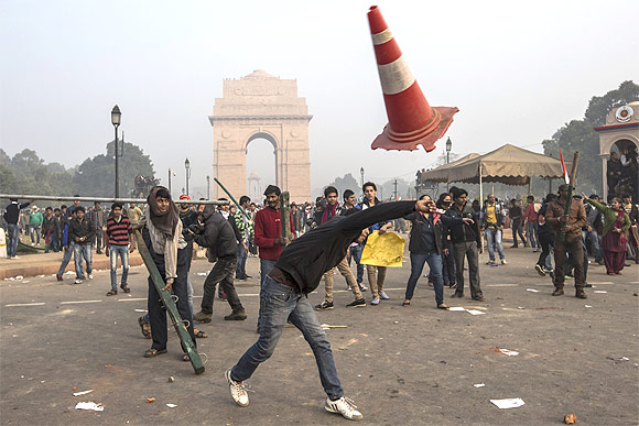 Protestors throw projectiles at Delhi police officers during a protest against the Indian governments reaction to recent rape incidents