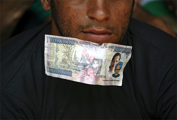 A fake currency note, with images of Prime Minister Manmohan Singh and Congress chief Sonia Gandhi, is worn by a protestor in New Delhi