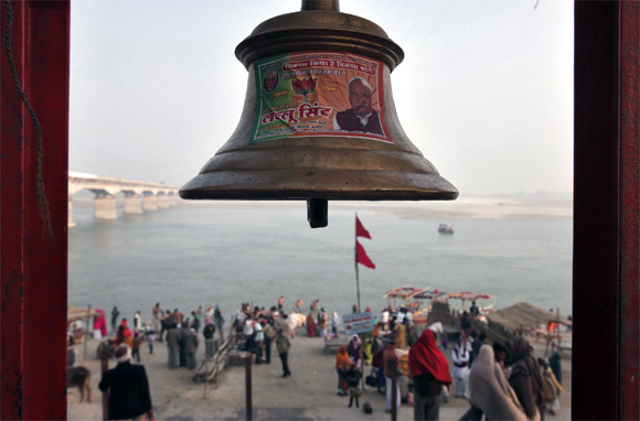 A temple bell pasted with a pamphlet of BJP is seen on the banks of the river Saryu in Ayodhya