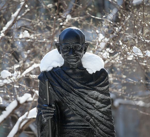 Snow blankets the shoulders of a statue of Mahatma Gandhi in Union Sqaure, New York
