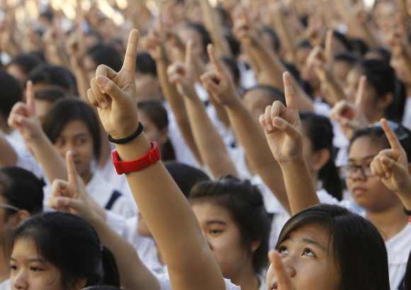 Thousands of students and faculty members dance to the theme song of the One Billion Rising campaign in the quadrangle of the St. Scholastica college in Manila