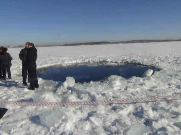 Russian police work near the ice hole created by the meteorite