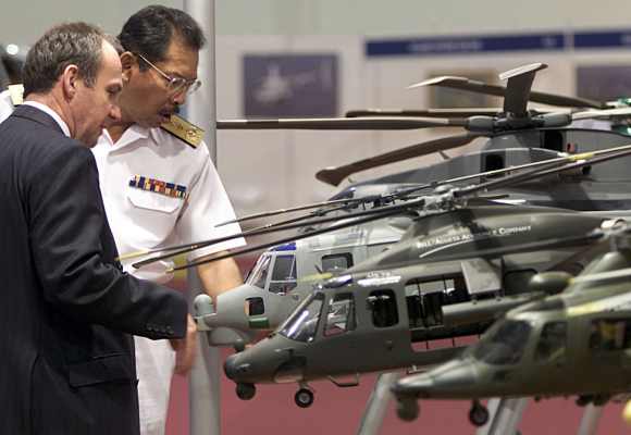 Visitors look at AgustaWestland model helicopters during Heli-Asia exhibition