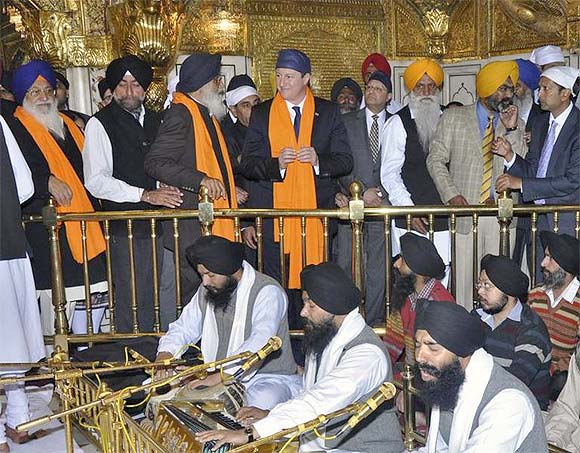 Britain's Prime Minister David Cameron speaks with Parkash Singh Badal, chief minister of Punjab, as he visits the holy Sikh shrine of Golden temple in Amritsar