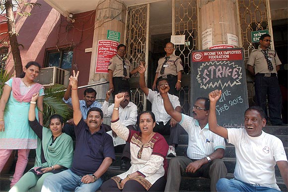 I-T department employees chant protest slogans outside a branch in Mumbai