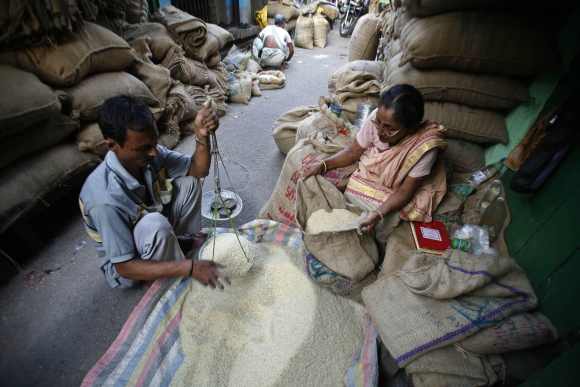 A shopkeeper weighs rice in a wholesale market in Kolkata