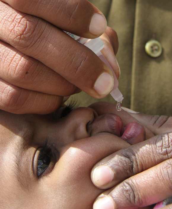 A child receives polio drops during the polio eradication programme