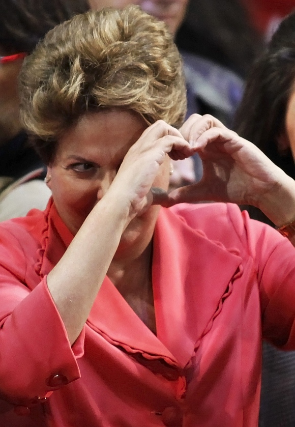 Brazil's President Dilma Rouseff of the Worker's Party shows a heart shape during a campaign rally in Sao Paulo