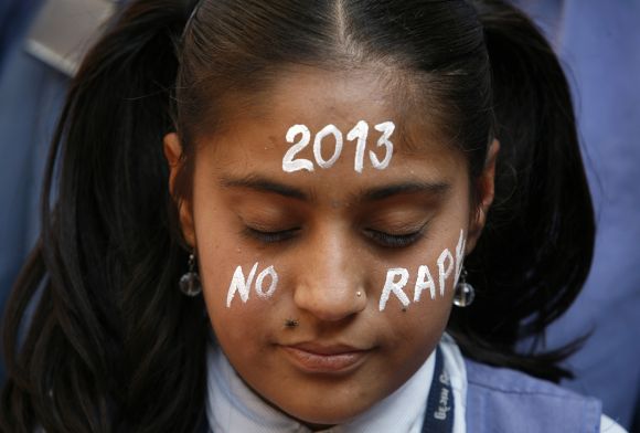 A student prays during a vigil for a gang rape victim, who was assaulted in New Delhi, in Ahmedabad