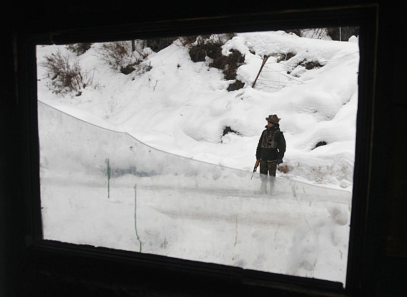 An Indian army soldier stands guard near the Line of Control in Churunda village, about 129 km northwest of Srinagar