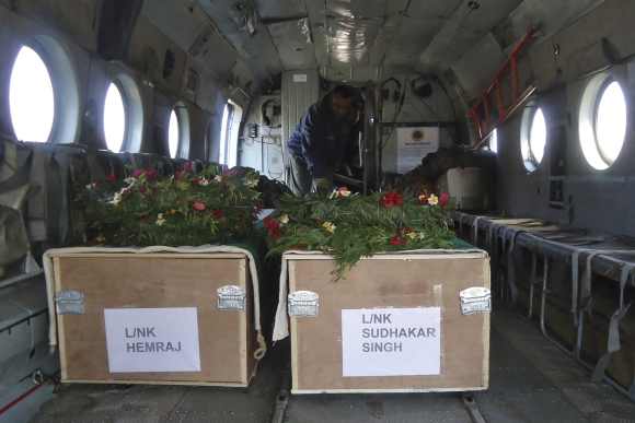 Two coffins containing the bodies of Indian Army soldiers are placed in a military helicopter at a garrison in Rajouri district