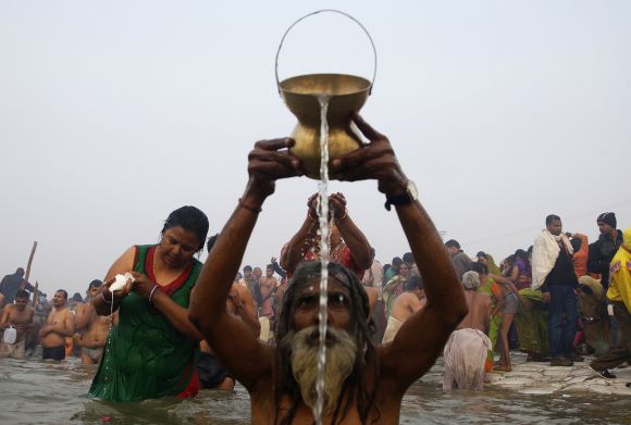 Devotees pray as they attend the first Shahi Snan at the ongoing Kumbh Mela in Allahabad on Monday