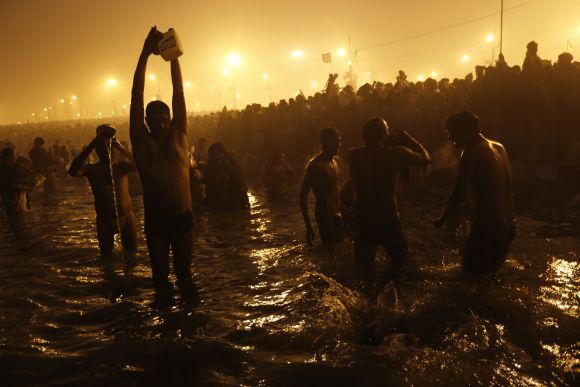 Devotees pray as they attend the first 'Shahi Snan' at the ongoing Kumbh Mela in Allahabad