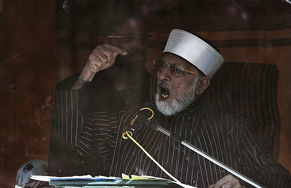 Sufi cleric and leader of the Minhaj-ul-Quran religious organisation Muhammad Tahirul Qadri addresses his supporters from behind the window of an armoured vehicle on the second day of protests in Islamabad