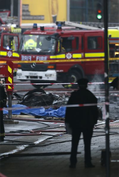 Smoke rises from debris as police and emergency services attend the scene of a helicopter crash in Vauxhall, south London