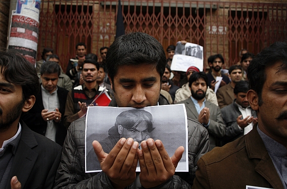 A journalist from the Balochistan Union Of Journalists holds a photograph of his colleague Imran Sheikh, who was killed in an explosion the day before, during a silent sit-in to protest against bomb blasts and condemn the killings of members of the media, outside the press club in Quetta