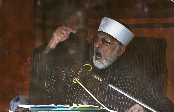 Dr Tahirul Qadri addresses his supporters from behind the window of an armoured vehicle during protests in Islamabad on Tuesday