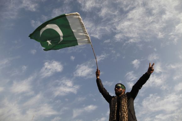 A supporter of Dr Qadri waves a Pakistan flag as he takes part in the second day of a protest in Islamabad