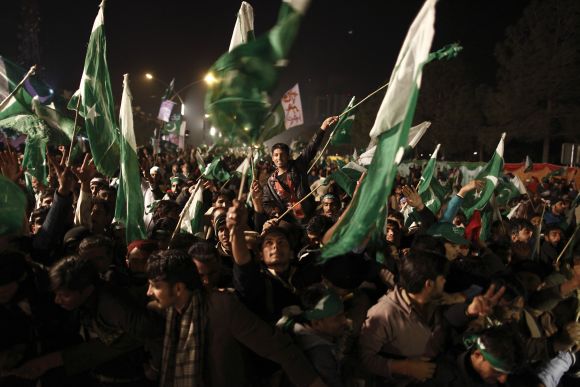 Supporters of Dr Qadri wave Pakistani flags during a protest in Islamabad on Tuesday