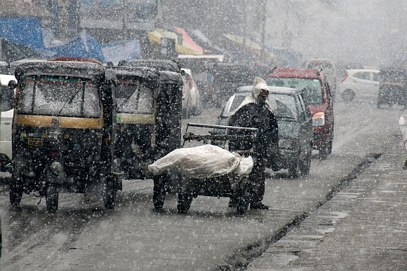Vehicles ply on roads during the snowfall in srinagar