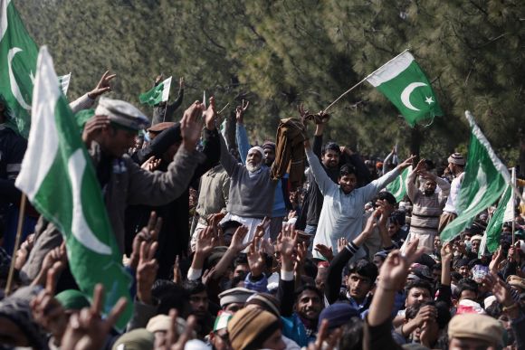 Supporters of Dr Qadri wave flags during a demonstration in Islamabad
