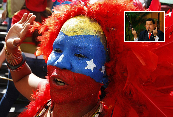 A supporter of Venezuelan President Hugo Chavez (inset) with her face painted in the colours of the national flag, attends a rally in Caracas
