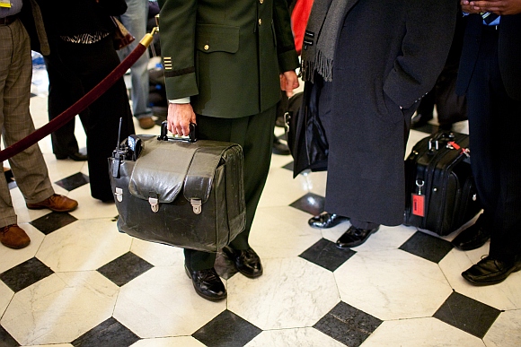 A military aide carries the nuclear football, with the nation's nuclear launch codes, through Statuary Hall as President Barack Obama arrives at the US Capitol for his address to a joint session of Congress on February 24, 2009 in Washington