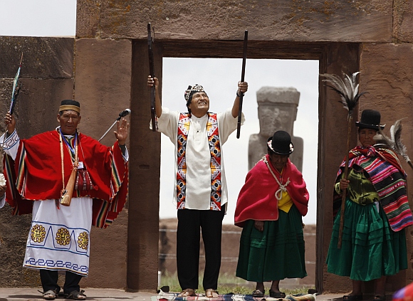 Bolivian re-elect President Evo Morales (second from left), accompanied by indigenous leaders, holds the staff of command during an Aymara indigenous ceremony at Tiwanaku