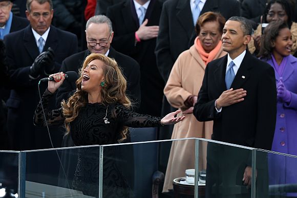 Singer Beyonce performs the national anthem as Obama looks on