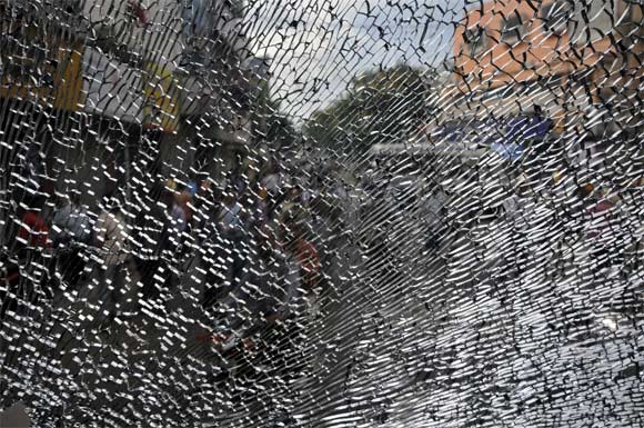 A broken window pane of a passenger bus is pictured after it was damaged by activists demanding a separate Telangana state