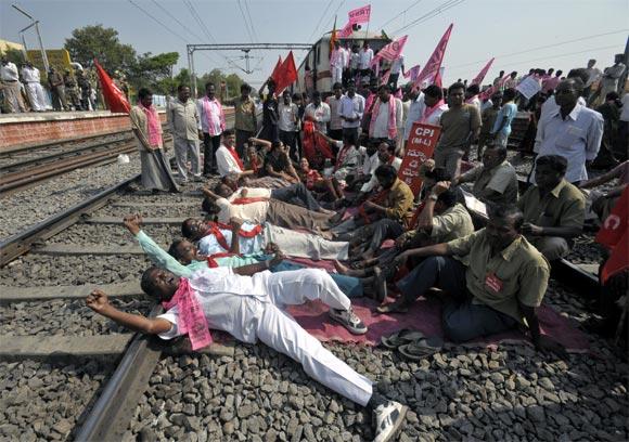 Pro-Telangana supporters shout slogans as they block the way of a passenger train during a protest at a railway station in Hyderabad