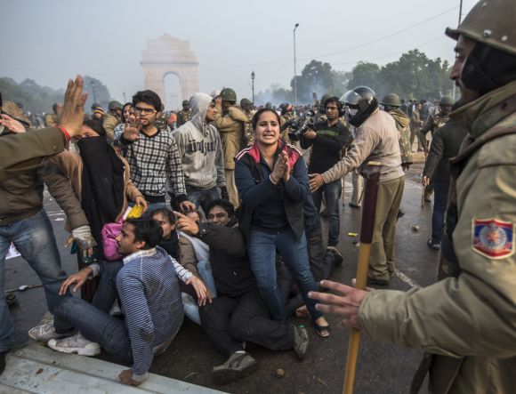 A protestor begs for mercy as Delhi police lathi charge during a protest