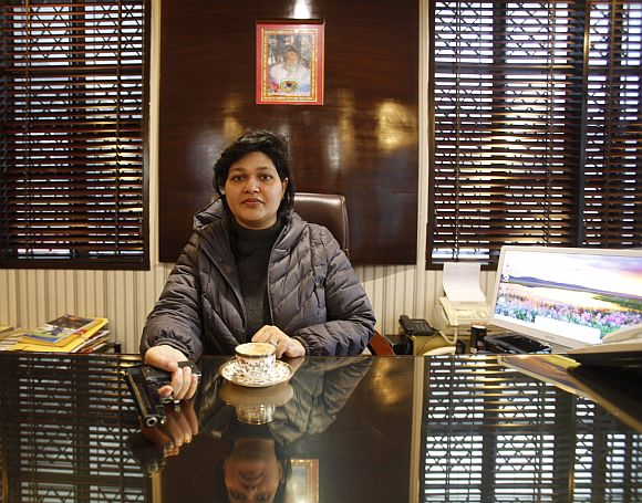 Nalini Bharatwaj, 37, chairman of a management institute, holds a gun while posing in her office in New Delhi