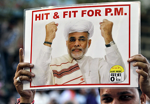 A BJP supporter holds a poster of Modi during a jubilation ceremony outside the party office in Ahmedabad
