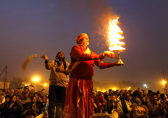 A Hindu priest performs evening prayers near the banks of the Ganga in Allahabad.