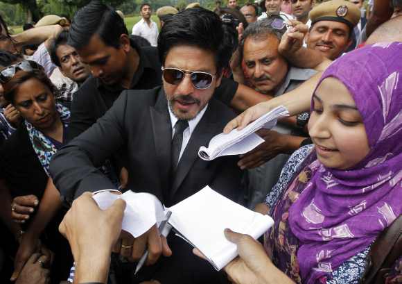 A fan gets an autograph from Khan