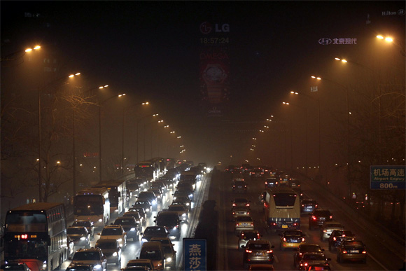 Cars drive along east 3rd Ring Road on a foggy evening in Beijing
